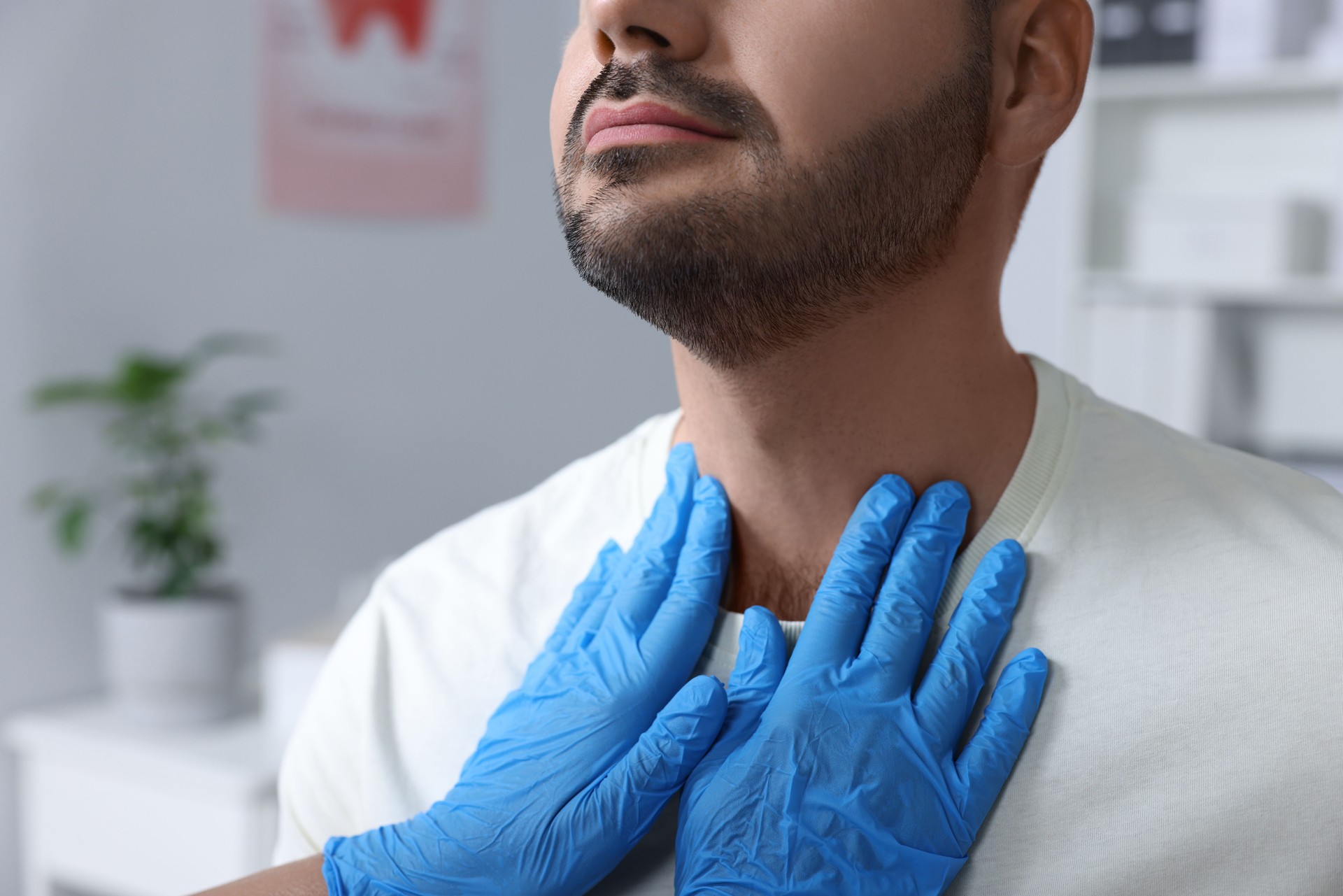 Endocrinologist examining thyroid gland of patient at hospital, closeup