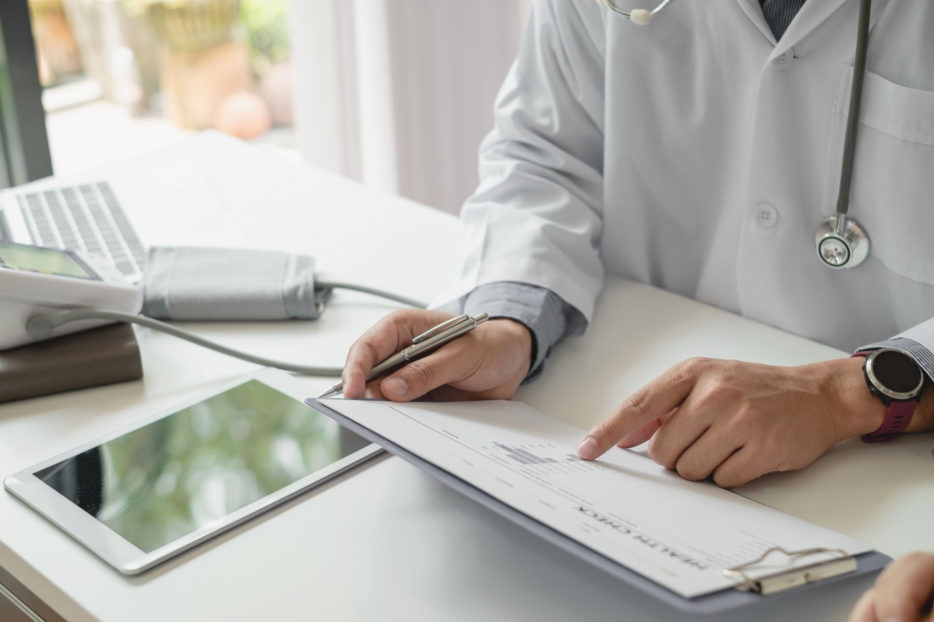 Doctor advise patients at the doctor's office room. Medical equipment placed on the table.