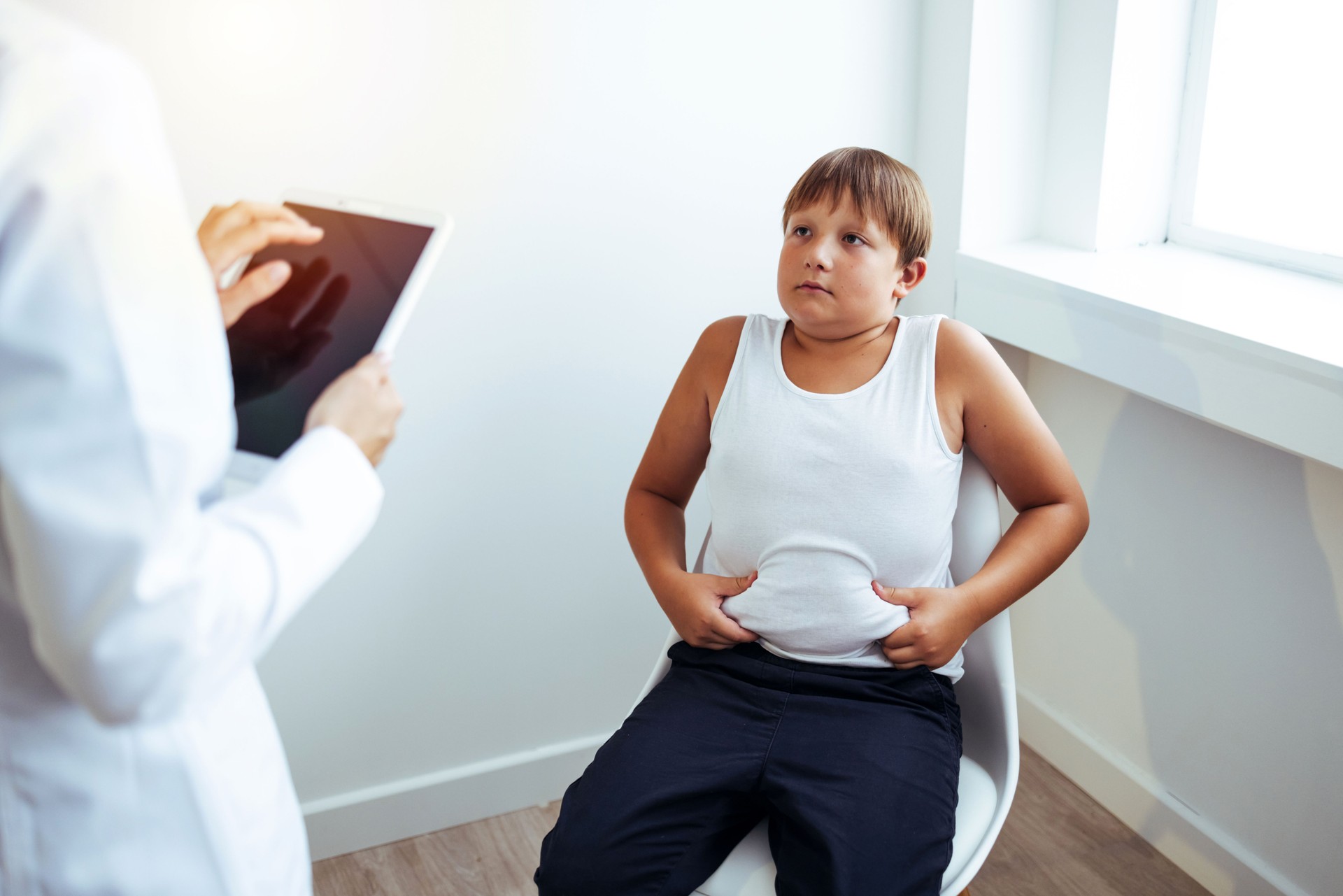 Obese child listening to nutritionist's recommendations.